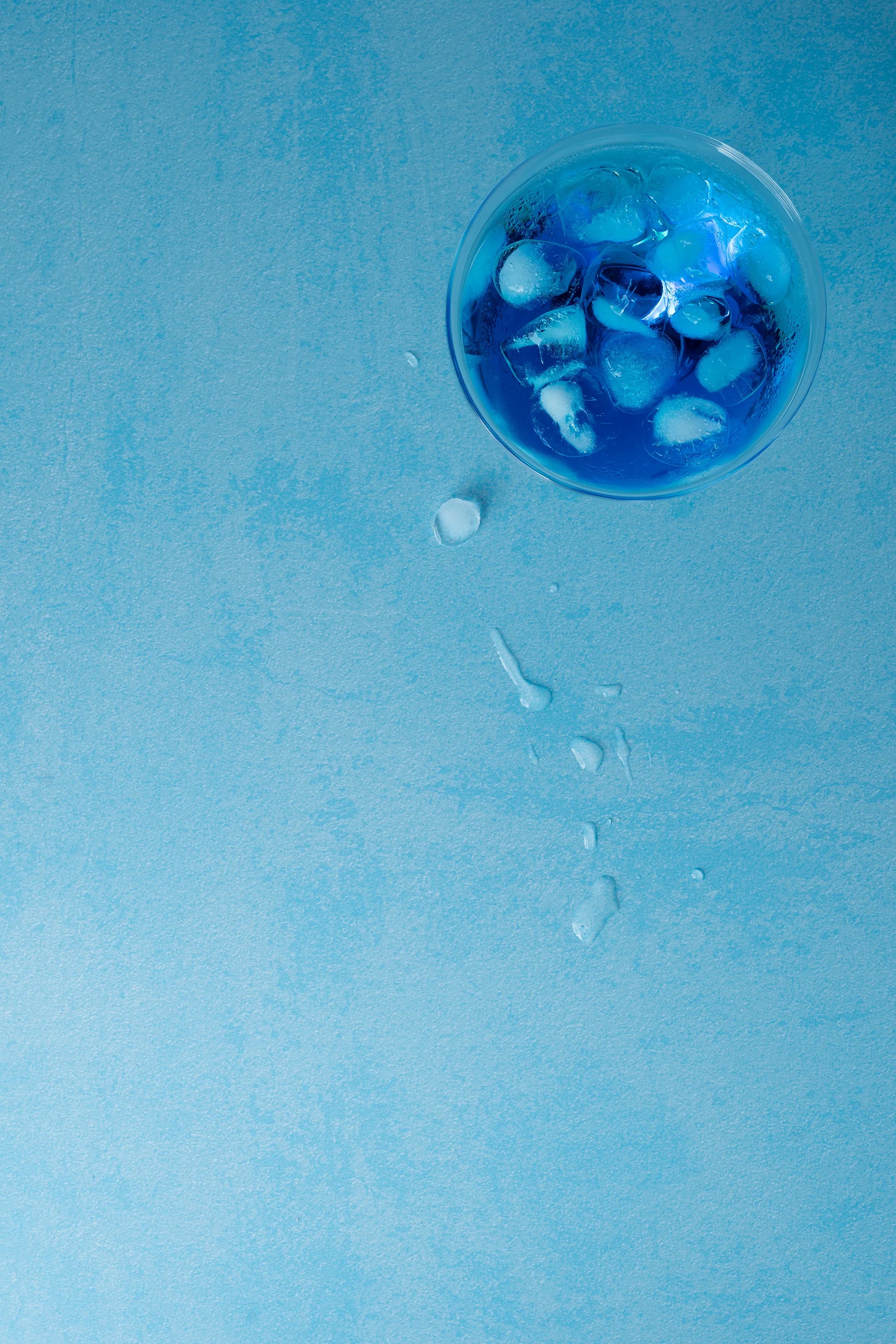 Foodfotografie blauer Drink mit Eiswürfeln auf Backdrop „Eisblau Textur“ – heller blauer Fotohintergrund