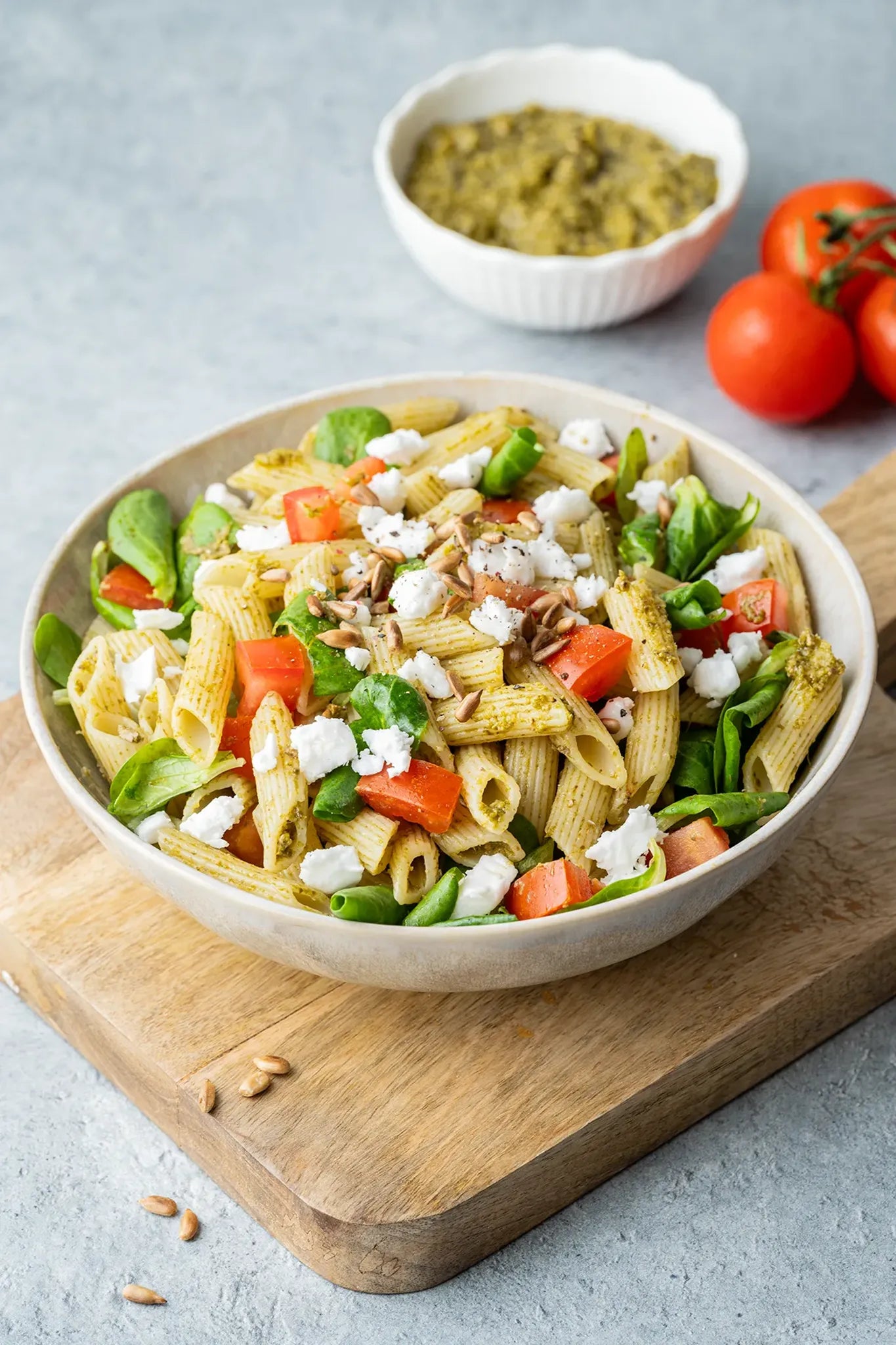 Vinyl Backdrop „Sonnenblumenkerne“ in strukturiertem Grau, hier als neutraler Untergrund für eine Foodaufnahme mit Pasta-Salat, ideal für minimalistische und natürliche Produktpräsentationen.