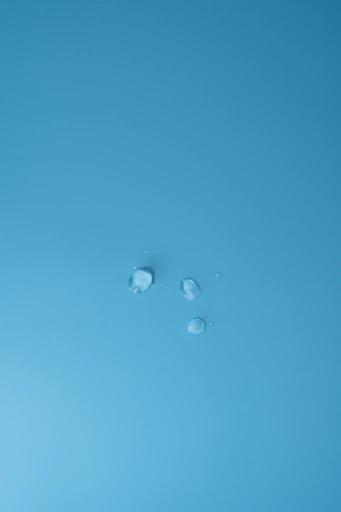 Detailaufnahme: Wassertropfen auf reflexionsarmer Oberfläche des Backdrop „Eisblau" – wasserfest und pflegeleicht