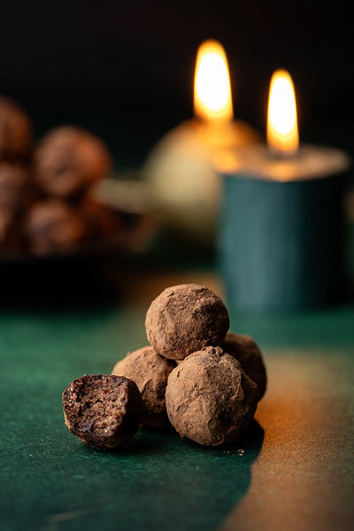 Schokoladentrüffel auf Backdrop „Feldsalat" – Dark & Moody Foodfotografie mit Kerzenlicht auf dunkelgrünem Fotohintergrund