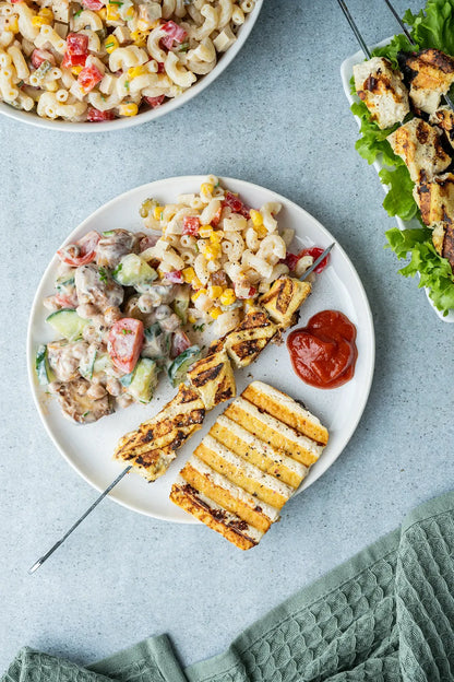 Vinyl Backdrop „Vanilleeis“ in strukturiertem Beige, verwendet als neutraler Hintergrund für sommerliche Foodfotografie mit Grillspießen, Nudel- und Kichererbsensalat – perfekt für lebendige Flatlays mit natürlichem Look.