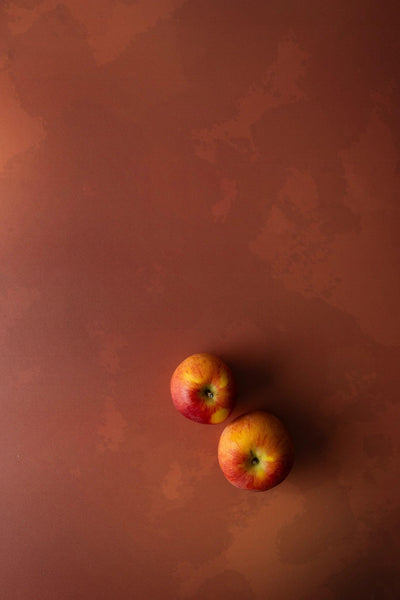 Foodfotografie zwei rote Äpfel auf Backdrop „Kürbissalat“ – warmer orange-brauner Fotohintergrund von BACKDROP SHOP
