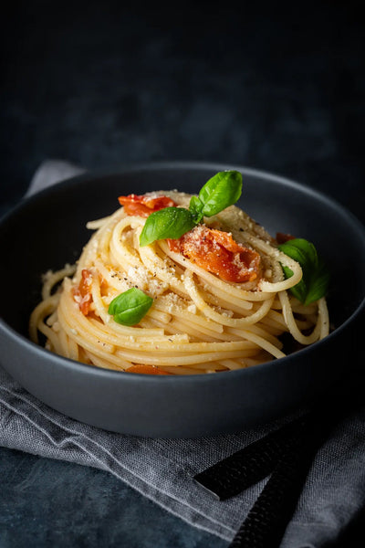 Spaghetti mit Tomaten und Basilikum vor Backdrop „Lakritz" – dunkel-dramatischer Farbcharakter von BACKDROP SHOP