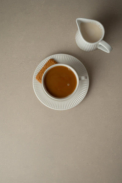 Foodfotografie Kaffeetasse mit Keks und Milchkännchen auf Backdrop „Vanilla Latte“ – cremiger Beige-Fotohintergrund von BACKDROP SHOP
